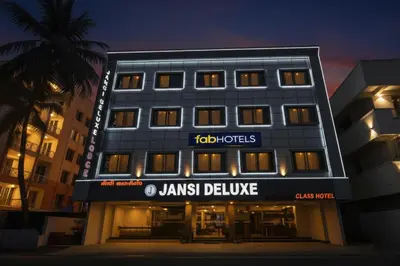 a building with a janish deluxe hotel at night at FabHotel Jansi Deluxe - Nr Gandhipuram Bus stand in Coimbatore