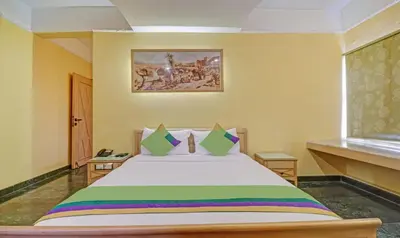 a bedroom with a large bed in a room at Treebo Komfort Suites, 3 Km From Mysore Palace in Mysore