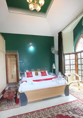 a bedroom with a large bed and a green wall at LikeMyHome Homestay Mysore in Mysore