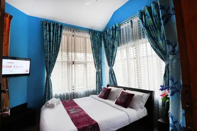a bedroom with a bed with blue walls and windows at LikeMyHome Homestay Mysore in Mysore