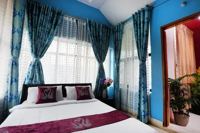 a bedroom with a bed with blue walls and windows at LikeMyHome Homestay Mysore in Mysore