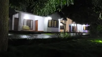 a white house at night with lights at Carpe DiemStay in Kushālnagar