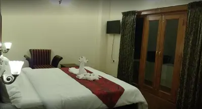 a bedroom with a bed with two stuffed animals on it at Golden Springs in Ooty