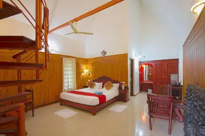a bedroom with a bed and a staircase in it at Misty Woods Resort in Kakkabe