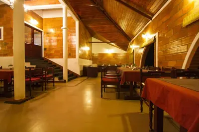a dining room with tables and chairs in a restaurant at Misty Woods Resort in Kakkabe