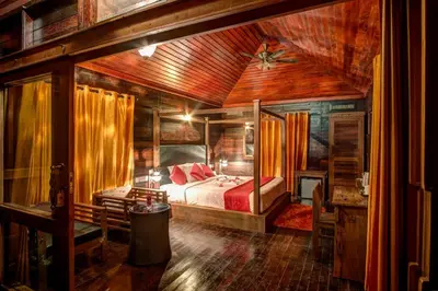 a bedroom with a bed and a wooden ceiling at Wild Planet Jungle Resort in Devāla