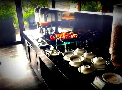 a stove top with a bunch of pots and pans at Roopa Elite in Mysore