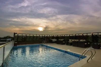 a swimming pool on the roof of a building at Roopa Elite in Mysore