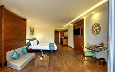 a hotel room with a bed and a couch at Roopa Elite in Mysore
