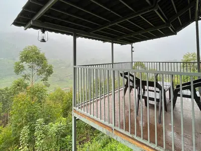 a bench sitting on a balcony with a view at NATURE CASTLE -Traditional villa,Vattavada in Kottakamboor