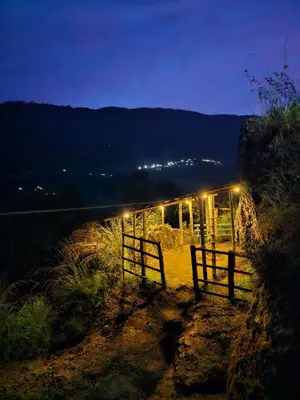 a barn with a fence and lights at night at NATURE CASTLE -Traditional villa,Vattavada in Kottakamboor