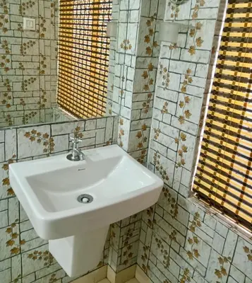 a bathroom with a white sink and a mirror at Kvm Tourist Home in Palakkad