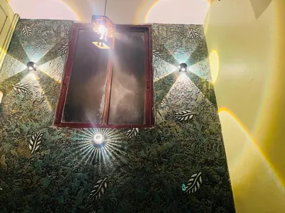 a bathroom with a mirror and lights on the wall at Kvm Tourist Home in Palakkad
