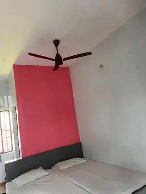a ceiling fan in a room with a bed at Kvm Tourist Home in Palakkad