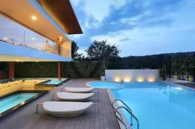 a house with a swimming pool with chairs and a table at Le Villagio Resort & Domes in Sultan Bathery