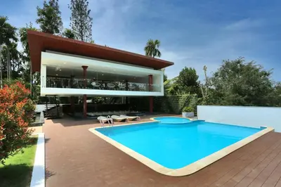 a large swimming pool in front of a house at Le Villagio Resort & Domes in Sultan Bathery