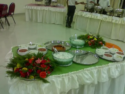 a table with bowls of food and flowers on it at Sree Gokulam Sabari in Guruvāyūr