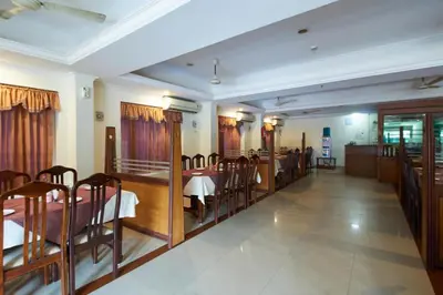 a dining room with a table and chairs in it at Sree Gokulam Sabari in Guruvāyūr