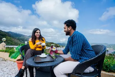 a man and woman sitting at a table drinking coffee at Tulips Valley View Resorts in Ooty