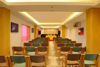 a room with chairs and a table in it at Park Residency Koyilandi in Quilāndi
