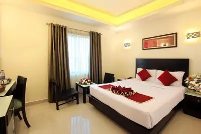 a hotel room with a bed and a desk and a bed at Park Residency Koyilandi in Quilāndi