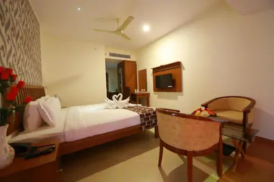 a bedroom with a bed and a table and a chair at Park regency in Angamali