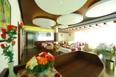 a restaurant with tables and chairs and flowers on a table at Park regency in Angamali