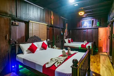 two beds in a room with wooden walls at Castillo De Woods , The Private Luxury Villa , 8 BHK, Vattavada in Kottakamboor