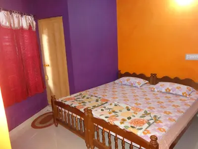 a bedroom with a bed with purple and orange walls at Four Seasons Home Stay (1BDH) in Madikeri