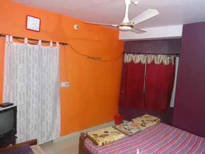 a bedroom with a bed and a ceiling fan at Four Seasons Home Stay (1BDH) in Madikeri