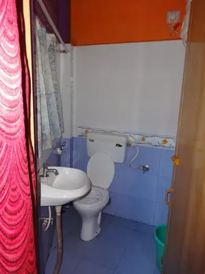 a small bathroom with a toilet and a sink at Four Seasons Home Stay (1BDH) in Madikeri