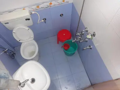 a blue bathroom with a toilet and a sink at Four Seasons Home Stay (1BDH) in Madikeri