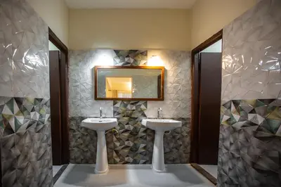a bathroom with two sinks and a mirror at KSTDC Hotel Mayura Hoysala, Mysore in Mysore