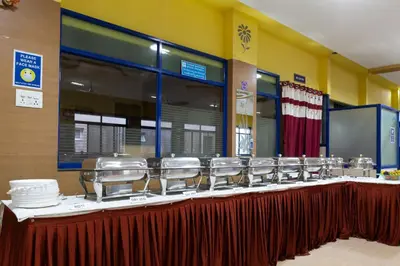 a long table with a row of plates and dishes at KSTDC Hotel Mayura Hoysala, Mysore in Mysore