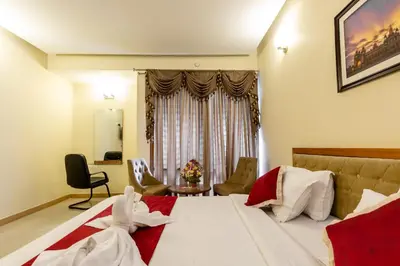 a hotel room with a bed and a window at KSTDC Hotel Mayura Hoysala, Mysore in Mysore