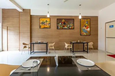 a dining room with two tables and chairs at KSTDC Hotel Mayura Kauvery KRS in Hosa Kannambādi