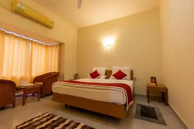 a bedroom with a large bed with red pillows at KSTDC Hotel Mayura Sangama Mekedatu in Mulhalli