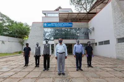 a group of men standing in front of a building at KSTDC Hotel Mayura Sangama Mekedatu in Mulhalli