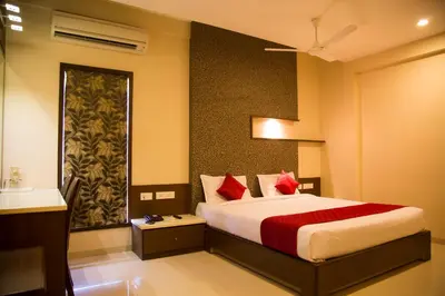 a bedroom with a large bed with red pillows at Hotel Sri Sakthi in Tiruppūr