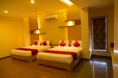 two beds in a room with yellow and red at Hotel Sri Sakthi in Tiruppūr