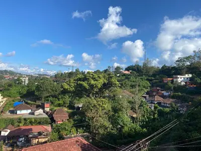 a village on a hill with houses and trees at Coorg North Breeze Homestay in Madikeri