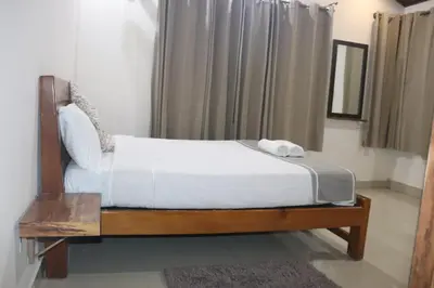 a bed in a room with a white bedvisor at Coorg North Breeze Homestay in Madikeri