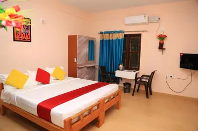 a bedroom with a bed with a television and a desk at Gooseberry Family Retreats - Wayanad by KARAPUZHA RESORTS in Meenangadi