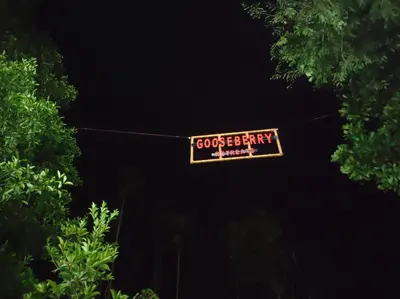 a sign hanging from a clothes line in the dark at Gooseberry Family Retreats - Wayanad by KARAPUZHA RESORTS in Meenangadi