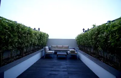 a balcony with a couch and a table and chairs at Radisson Blu Coimbatore in Coimbatore