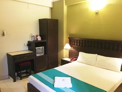 a bedroom with a bed and a desk with a tv at Hotel Palace Tower in Trichūr