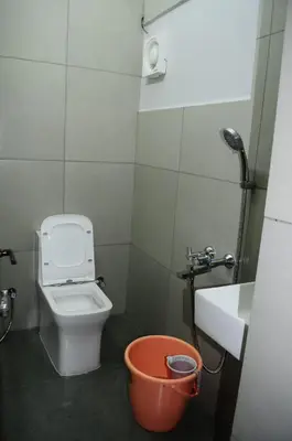 a small bathroom with a toilet and a sink at Park corner Home stay in Coonoor