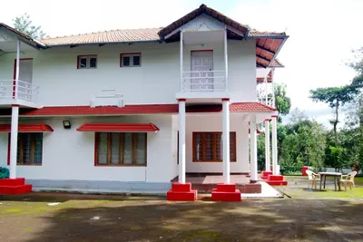a white house with a red roof at Vacanza Estate House in Kakkabe