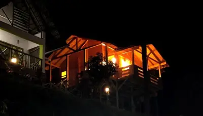 a house at night with its lights on at Woodrose Resort in Kalpetta