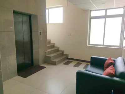 a waiting room with a blue couch and stairs at Banyan Tree Comforts Mysore in Mysore